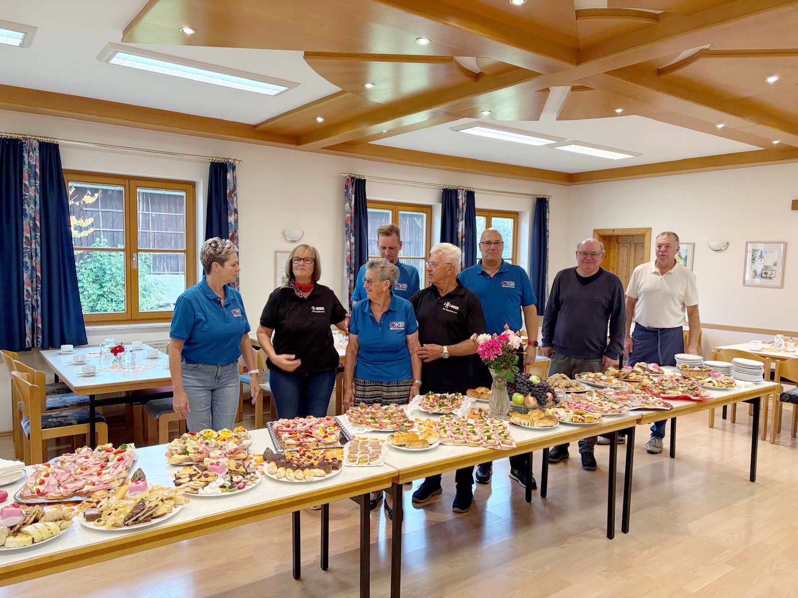 Personen bei Buffet mit vielen kleinen Speisen und Getränken in einem Raum